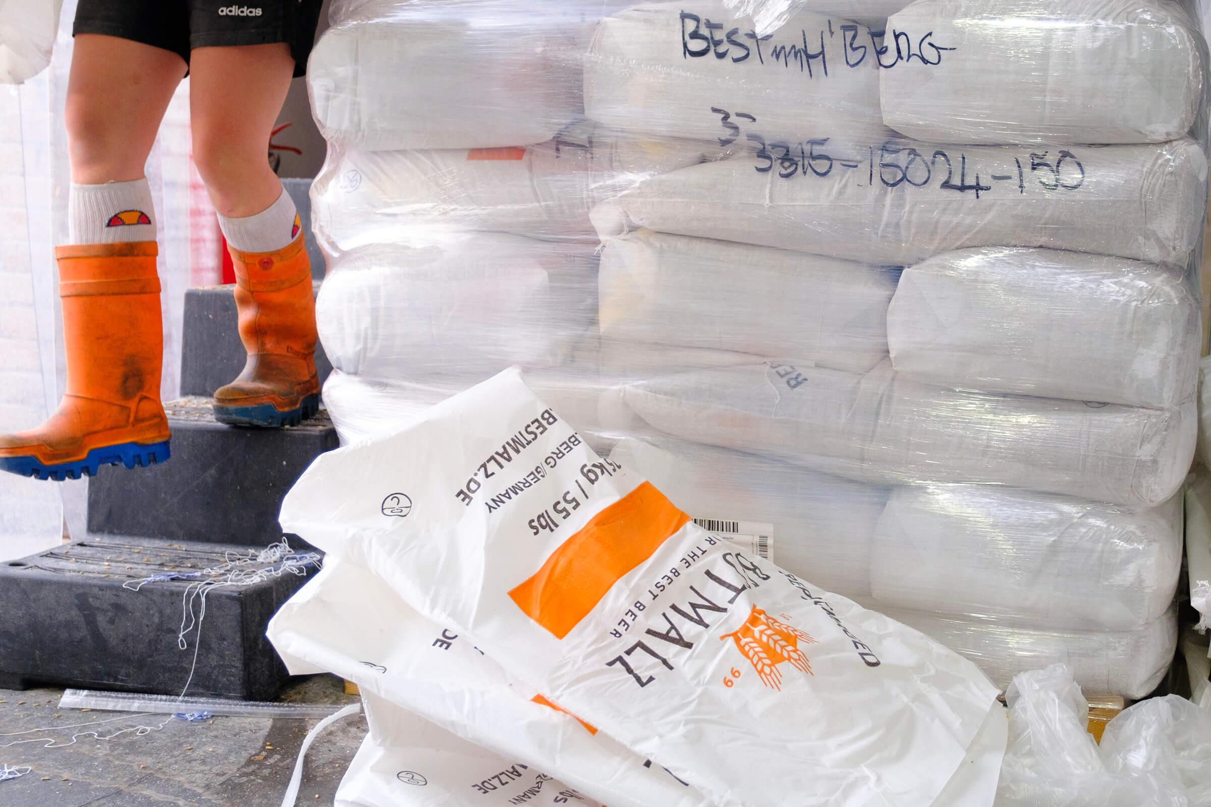 A stack of BESTMALZ BEST Heidelberg malt beside the hopper at Track Brewery in Manchester, UK.