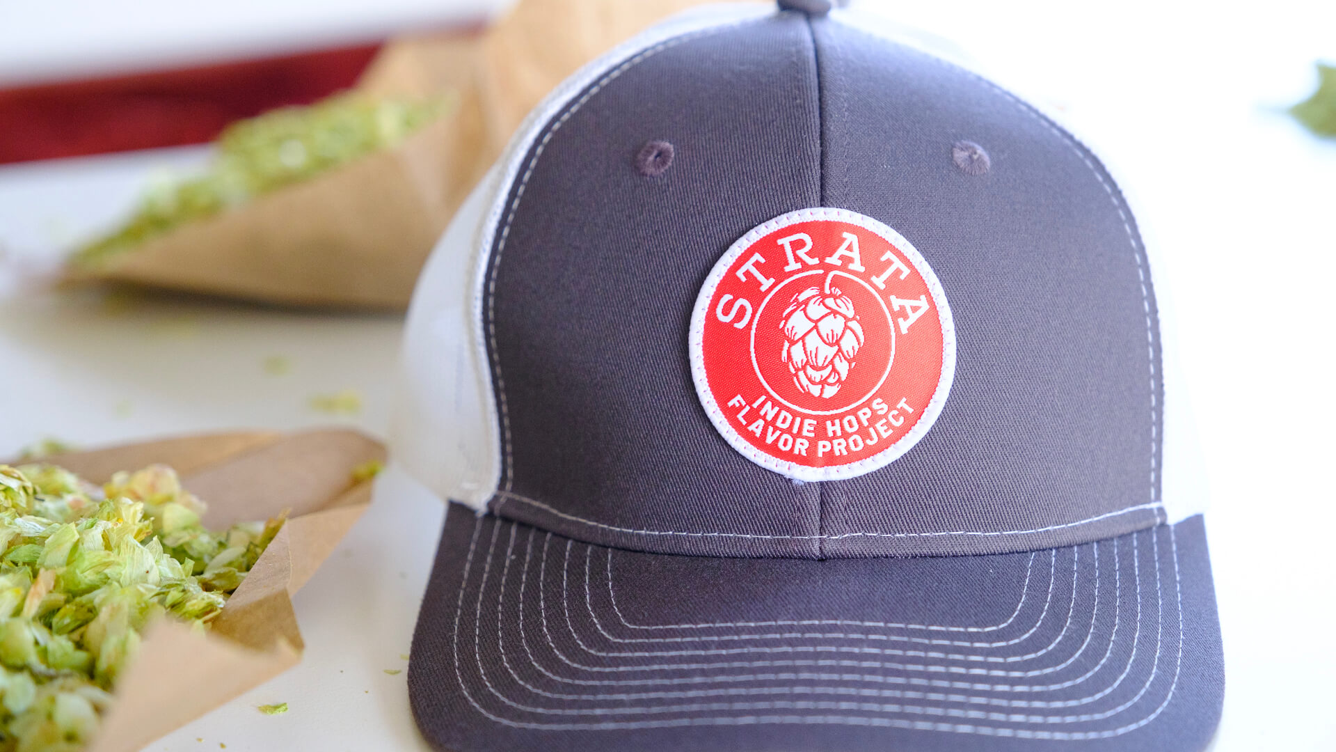 Indie Hops Strata hat on a table next to lots of Indie Hops Strata® during DEYA’s 2024 Strata® hop selection in Oregon, USA
